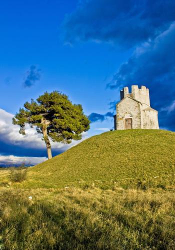 a castle on top of a hill with a tree at Apartment in Nin with Terrace, Air conditioning, Wi-Fi (3718-1) in Nin
