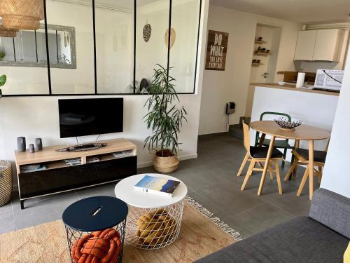- un salon avec une télévision et une table dans l'établissement Chez Isa, loft 55m2, jardin, vue, parking, entrée autonome, à Ceyrat