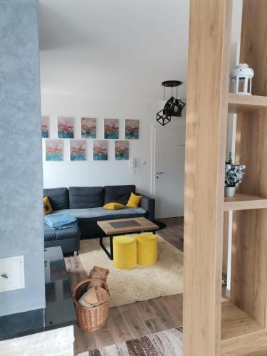 a living room with a blue couch and yellow accents at Apartmani Dimitrije Jahorina in Jahorina