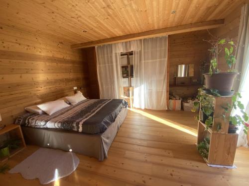 um quarto com uma cama num quarto de madeira em Chalet Miel de la Cayolle-Estenc em Entraunes