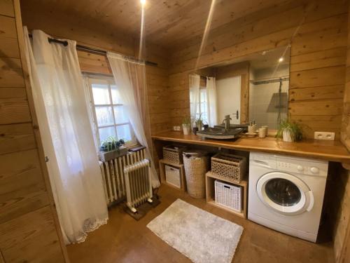 uma cozinha com uma máquina de lavar roupa num quarto em Chalet Miel de la Cayolle-Estenc em Entraunes
