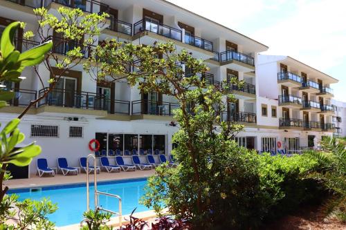 a hotel with a swimming pool in front of a building at Guya Wave Hotel in Cala Ratjada