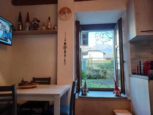 a dining room with a table and a window at Appartamento gaiulin in Pinzolo