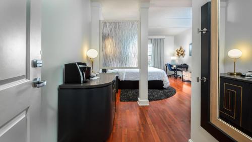 1 dormitorio con cama y escritorio con espejo en Hotel Indigo Jacksonville-Deerwood Park, an IHG Hotel en Jacksonville