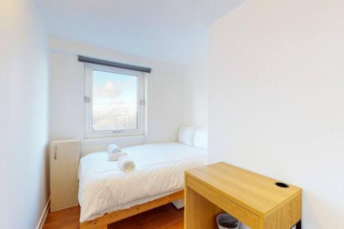 a small bedroom with a bed and a window at Stylish 2-bedroom flat in Bethnal Green in London
