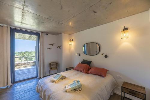 a bedroom with a bed and a large window at Appartement Dea in Sainte-Lucie de Porto-Vecchio