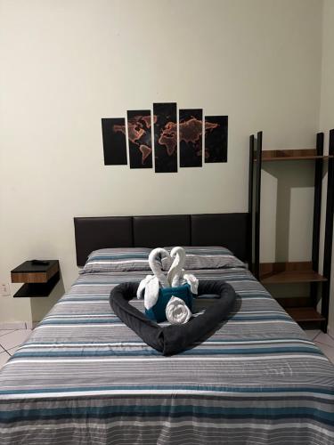 two stuffed animals in a ring on a bed at Pousada Meraki Beach in Caraguatatuba