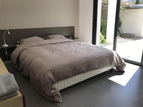 a large bed in a bedroom with a large window at Villa Alberes Sorede 7 km of beaches in Sorède