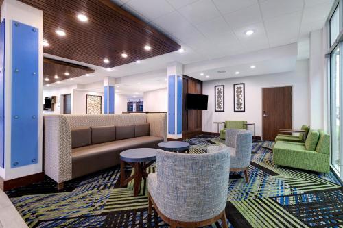 a lobby with a couch and tables and chairs at Holiday Inn Express & Suites - Grand Rapids South - Wyoming by IHG in Wyoming