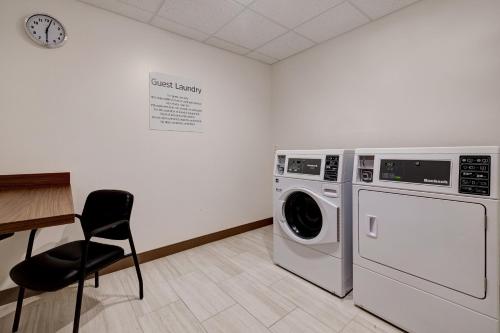 a laundry room with a washing machine and a chair at Holiday Inn Express & Suites - Grand Rapids South - Wyoming by IHG in Wyoming