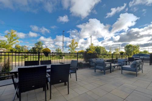 a patio with tables and chairs and a fence at Holiday Inn Express & Suites - Grand Rapids South - Wyoming by IHG in Wyoming