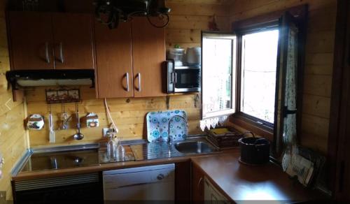 una pequeña cocina con fregadero y ventana en Apartamento EL Paso en Fuentelisendo