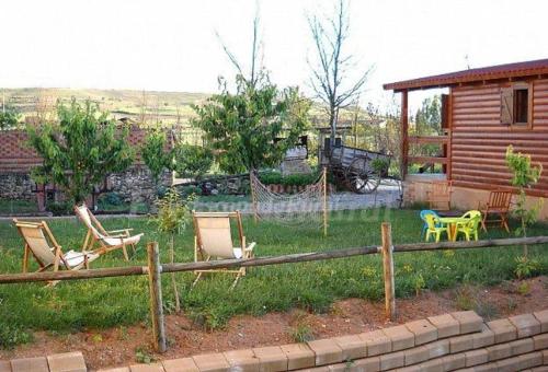 a yard with chairs and a wooden fence at Apartamento EL Paso in Fuentelisendo