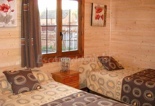 1 dormitorio con 2 camas y ventana en Apartamento EL Paso en Fuentelisendo