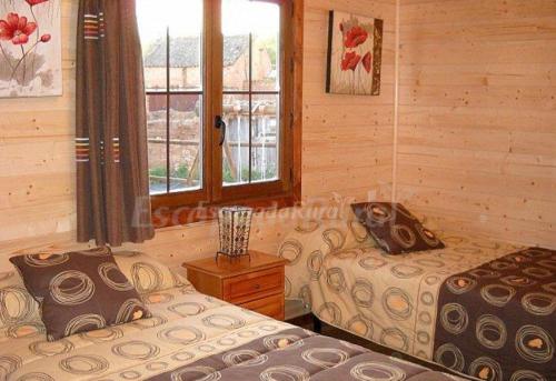 a bedroom with two beds and a window at Apartamento El Paso in Fuentelisendo