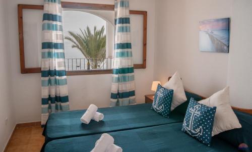 um quarto com uma cama verde e uma janela em Aldeas Taray Admer 12 em La Manga del Mar Menor