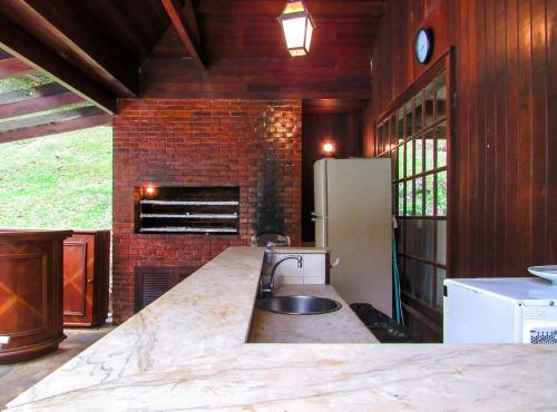 cocina con fregadero y nevera en Casa de campo Lirio c piscina e churrasqueira - RJ, en Teresópolis
