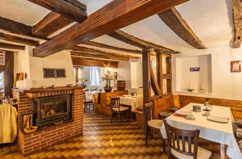 a living room with a fireplace and tables and chairs at Hotel-Gasthof zum Ritter in Haßmersheim