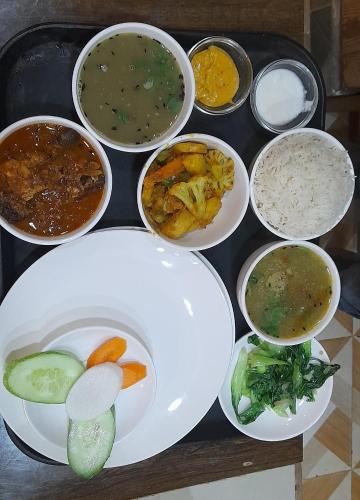 a tray with bowls of different types of food at Paradise Villa in Nagarkot