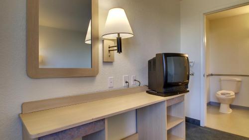 a television sitting on a counter in a bathroom at Motel 6-Owensboro, KY in Owensboro