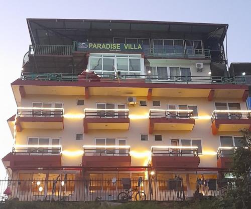a tall building with balconies and a sign on it at Paradise Villa in Nagarkot