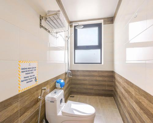 a bathroom with a toilet and a window at Vuon Xuan Hotel - STAY 24H in Da Lat