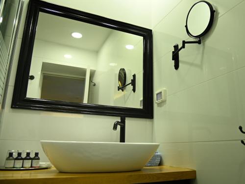a white sink sitting under a mirror in a bathroom at Carmella Boutique Hotel in Haifa