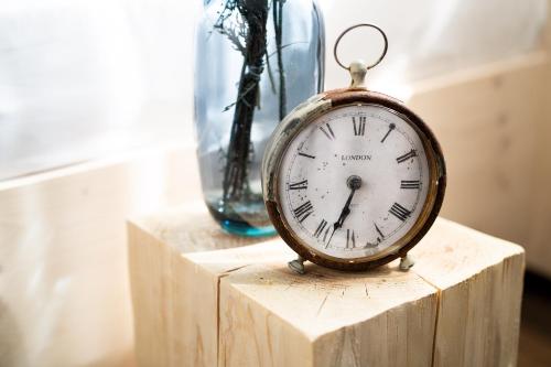 a clock sitting on top of a wooden block at Gartenhotel Fettehenne in Erkrath