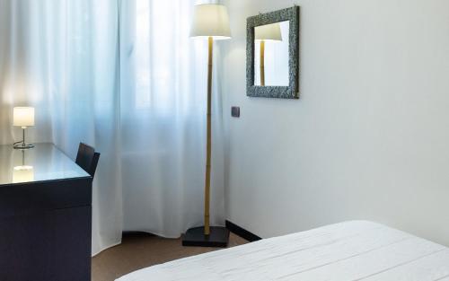 a bedroom with a bed and a mirror on the wall at Hotel Mosaico in Ravenna