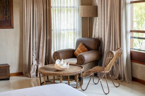 a living room with a chair and a table at Villa Manis Beachfront Candidasa in Candidasa