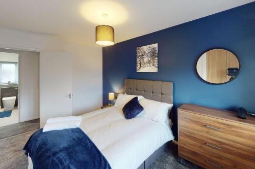 ein Schlafzimmer mit einem großen Bett und einer blauen Wand in der Unterkunft HU-Nine Dock House - Sleeps 4 in Hull
