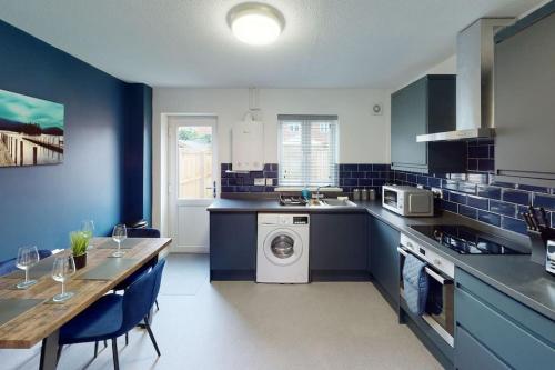 a kitchen with a table and a washing machine in it at HU-Nine Dock House - Sleeps 4 in Hull