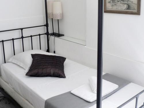 a bedroom with a bed with white sheets and a lamp at Chanteclair in Cannes