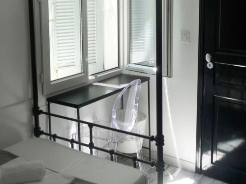 a kitchen with a glass table and two windows at Chanteclair in Cannes