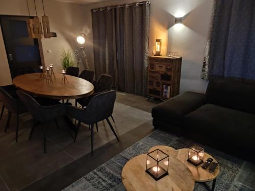 uma sala de estar com uma mesa e um sofá em Gîte La Renéade 