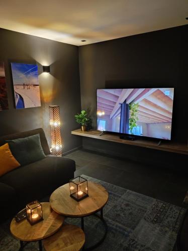 a living room with a couch and a flat screen tv at Gîte La Renéade in Foyr
