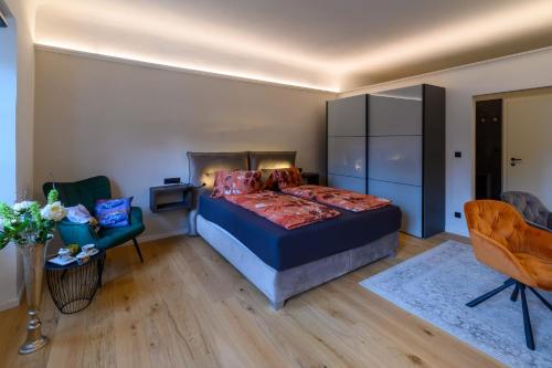 ein Schlafzimmer mit einem Bett und einem Stuhl in der Unterkunft Gh Alte Post - Top 5 Gt in Gmünd in Kärnten