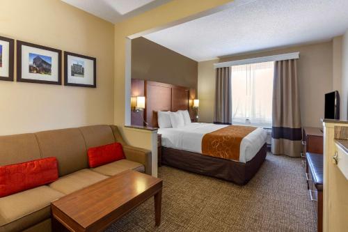 a hotel room with a bed and a couch at Comfort Suites Raleigh Walnut Creek in Raleigh