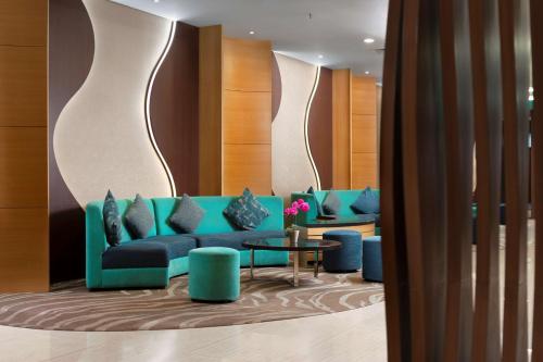 a living room with a blue couch and a table at Best Western The Lagoon Hotel in Manado