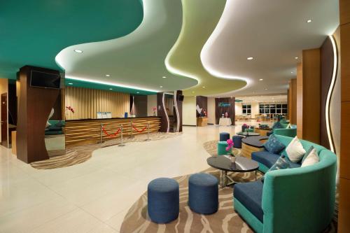a lobby of a hotel with blue chairs and tables at Best Western The Lagoon Hotel in Manado
