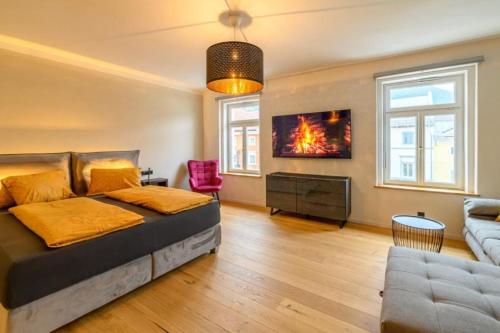 een slaapkamer met een bed en een bank bij Gh Alte Post - Top 7 Admiral in Gmünd in Kärnten