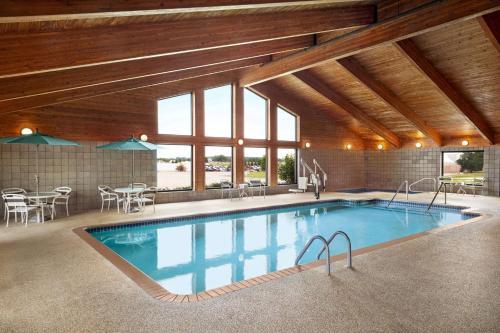 a large swimming pool in a building with windows at AmericInn by Wyndham Sauk Centre in Sauk Centre