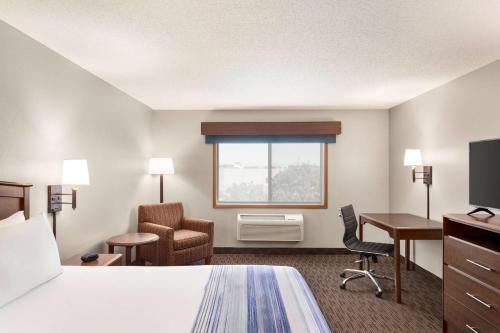 a hotel room with a bed and a desk and a window at AmericInn by Wyndham Sauk Centre in Sauk Centre