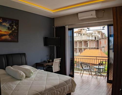 - une chambre avec un lit et une vue sur un balcon dans l'établissement Berawa Homestay, à Canggu