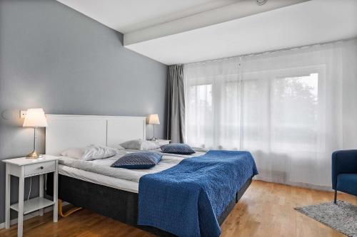 a bedroom with a large bed with a blue blanket at Best Western Hotel Varnamo in Värnamo