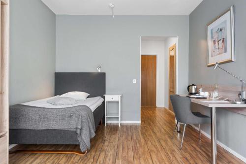 a bedroom with a bed and a desk and a table and chair at Best Western Hotel Varnamo in Värnamo