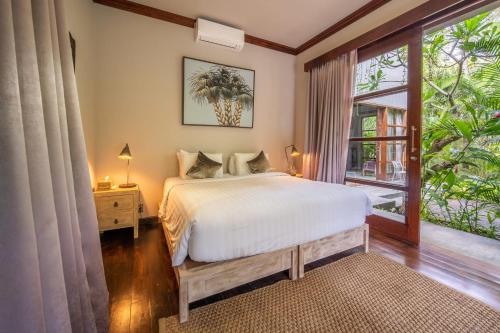 a bedroom with a bed and a window at Villa Manis Beachfront Candidasa in Candidasa