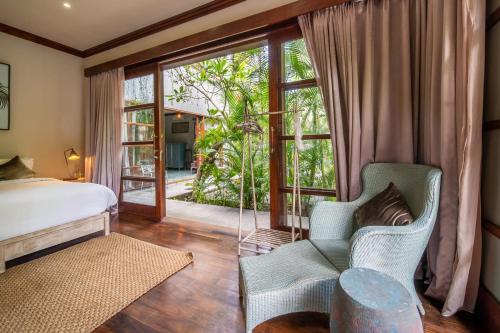 a bedroom with a bed and a large window at Villa Manis Beachfront Candidasa in Candidasa