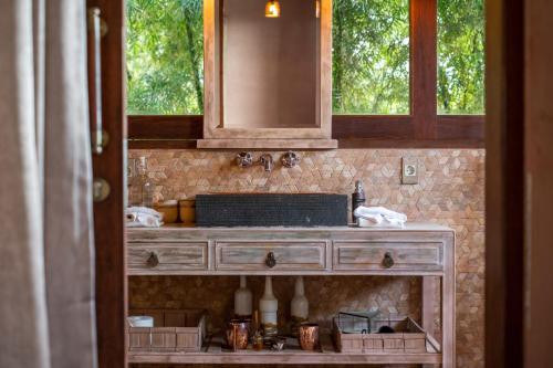 a kitchen counter with a sink and a mirror at Villa Manis Beachfront Candidasa in Candidasa