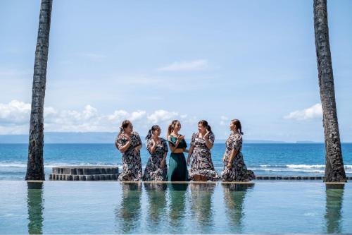 a group of women standing in water near the ocean at Villa Manis Beachfront Candidasa in Candidasa